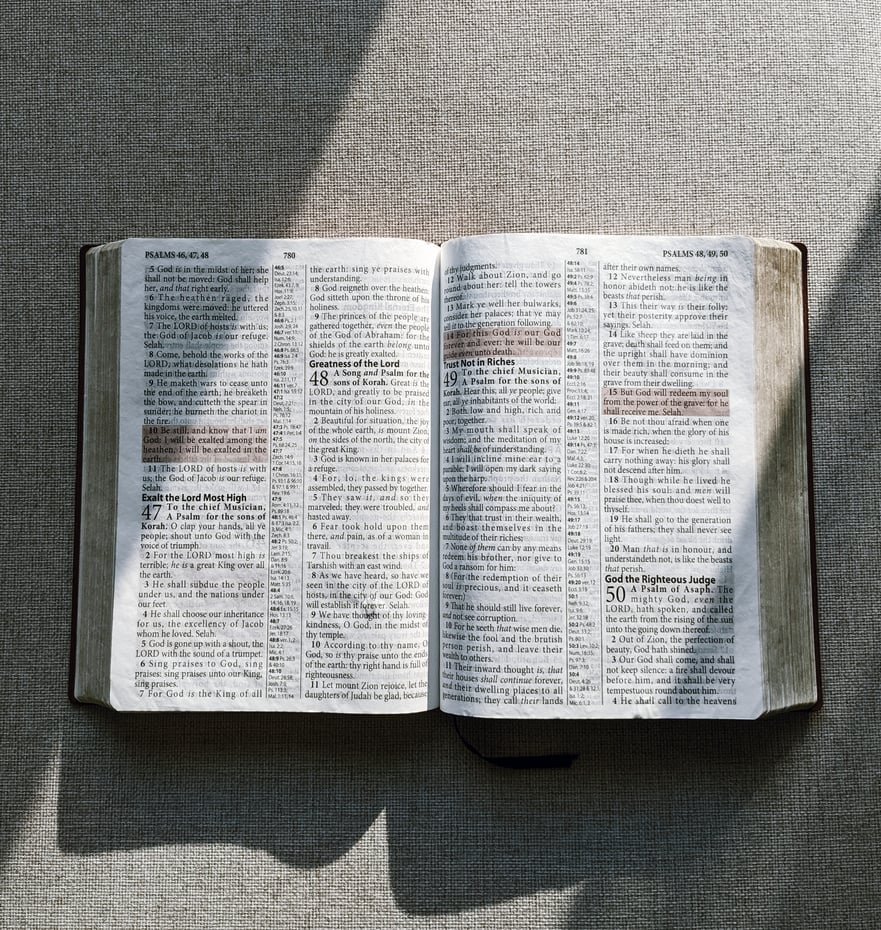 Close-Up Shot of a Bible on Gray Textile